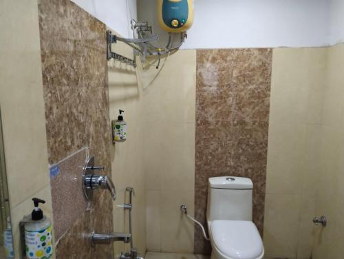 uma casa de banho com um WC branco num quarto em PuHoR Hotel Plaza Inn em Guwahati