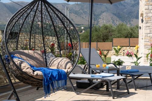 a swing with chairs and tables on a patio at Sirena Villa in Chania Town