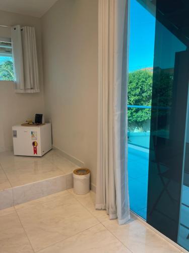 a room with a glass door with a window at Charlotte House in Canoa Quebrada