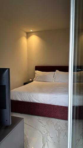 a bedroom with a bed and a flat screen tv at Palazzo Maqueda in Palermo