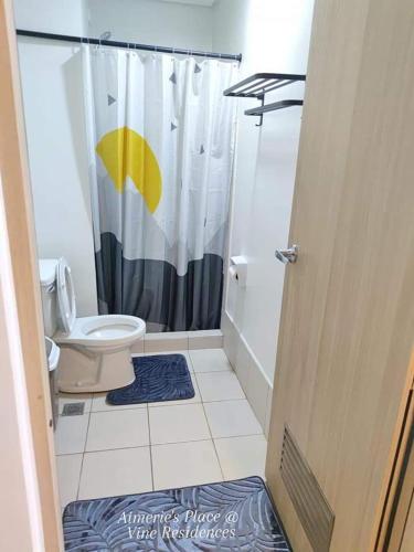 a bathroom with a shower with a toilet and a shower curtain at Vine Residences -Cozy 2BR with Balcony in Manila