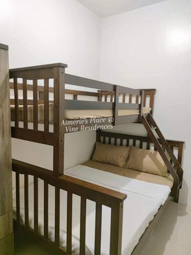a wooden bunk bed with white sheets and pillows on it at Vine Residences -Cozy 2BR with Balcony in Manila