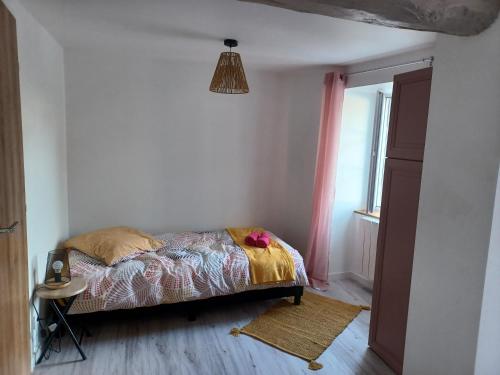 Schlafzimmer mit einem Bett und einem Fenster in der Unterkunft Duplex cosy et douillet in Ernée