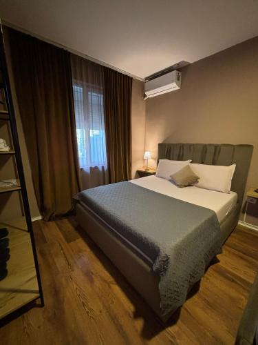a bedroom with a bed and a large window at BejartApartment2 in Tirana