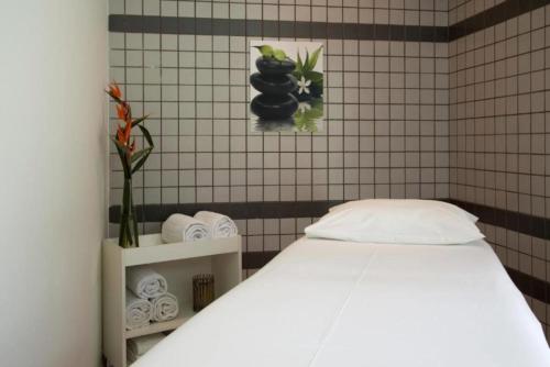 a bedroom with a white bed and a tiled wall at George V Alto de Pinheiros Apto 208 Luxo - Adm Privada - Café da manhã in Sao Paulo