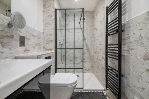 a bathroom with a toilet and a tub and a sink at Luxury 1 Bed Flat - Shoreditch, Spitalfields & The City of London in London