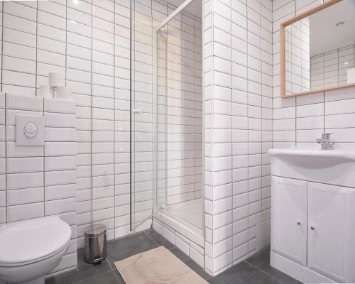 a white bathroom with a toilet and a shower at Hostel Vertigo Vieux-Port in Marseille