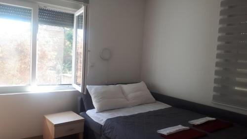 um pequeno quarto com uma cama e uma janela em Guest house Limes em Zatonje