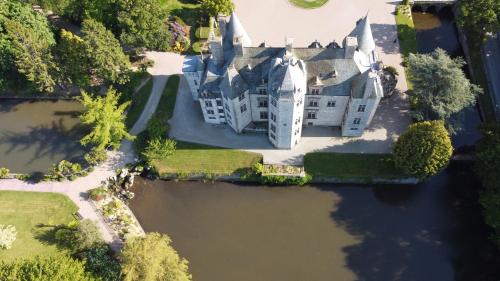- une vue aérienne sur un château sur un lac dans l'établissement Le Chalet du Clos Giot, à Saint-Vaast-la-Hougue