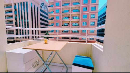 a table on a balcony with a view of buildings at DXB HOSTEL Near ADCB Metro Station in Dubai