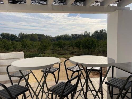 2 Tische und Stühle auf einer Terrasse mit Aussicht in der Unterkunft Estupenda casa rural en Hinojos in Hinojos