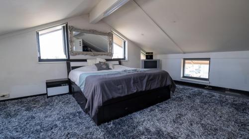 カペレ・アーン・デン・エイセルにあるBig 5-bedroom house in Capelle aan den IJsselのベッドルーム(大型ベッド1台、鏡付)
