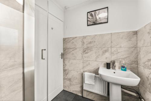 y baño blanco con lavabo y ducha. en Stunning Abode in Ashford - Parking - Sleeps 7, en Skegby