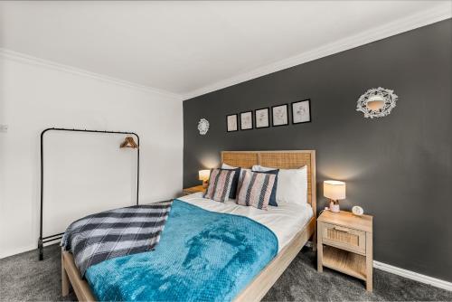 um quarto com uma cama com um cobertor azul em Stunning Abode in Ashford - Parking - Sleeps 7 em Skegby
