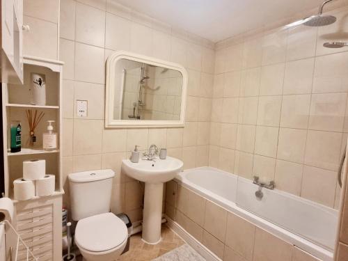 a bathroom with a sink and a toilet and a bath tub at Spacious two bedroom apartment with one parking space in Thame