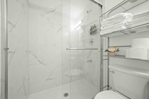 y baño blanco con ducha y aseo. en Entire NEW Cozy and Modern 2-storey HOUSE, en Vancouver
