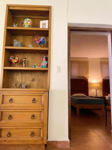 a wooden dresser in a room with a bedroom at LAS ALAMEDAS Departamentos céntricos con estacionamiento privado in Guanajuato