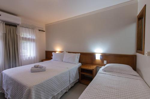 a hotel room with two beds and a window at Pousada Villa Verde in Canela