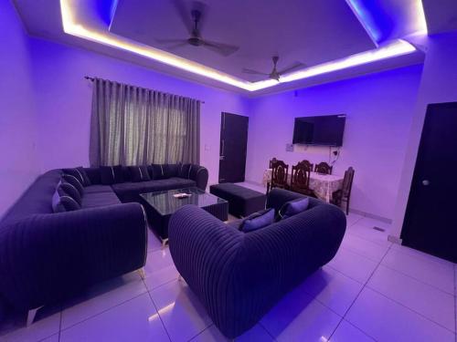 a living room with couches and a tv and purple lighting at Luxury 3bhk villa (mere bebe da villa)@gopal nagar in Jalandhar
