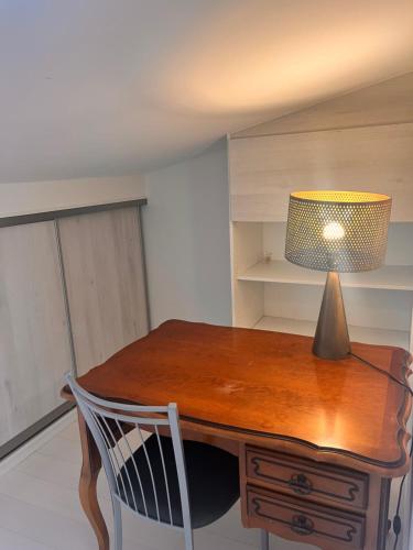 un bureau en bois avec une lampe et une chaise dans l'établissement Belle chambre spacieuse, tropézienne, vue remparts, clim, parking, à Aigues-Mortes