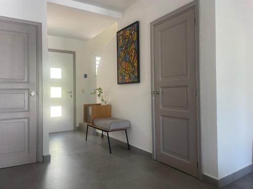 a hallway with a door and a bench and a painting at Orient Bay Villa in Orient Bay