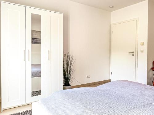 a white bedroom with a bed and a closet at Tarnewitz Pierre Wohnung Pierre 01 in Tarnewitz