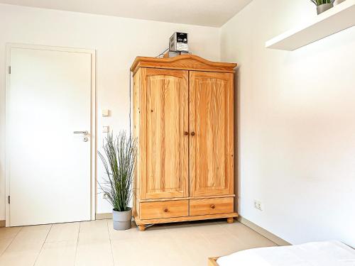 a wooden cabinet in the corner of a room at Tarnewitz Pierre Wohnung Pierre 01 in Tarnewitz