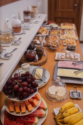 a table topped with plates of food and fruit at Pousada Villa Verde in Canela
