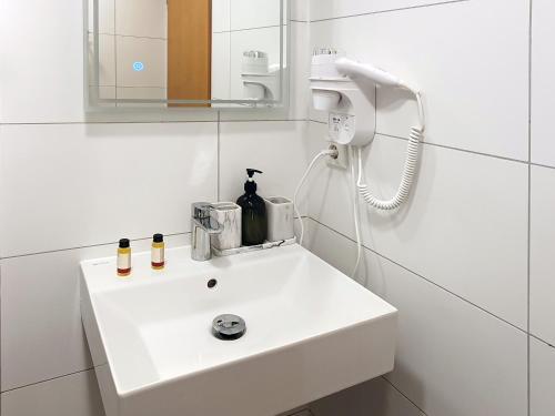 a bathroom with a white sink and a mirror at Rheinmetropole Hotel in Düsseldorf