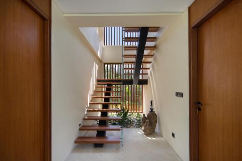 un escalier dans une maison avec des balustrades en bois dans l'établissement Villa Serangan - Private Beach Access, à Selong Belanak