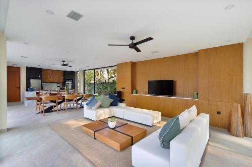 ein Wohnzimmer mit weißen Möbeln und ein Esszimmer in der Unterkunft Villa Serangan - Private Beach Access in Selong Belanak