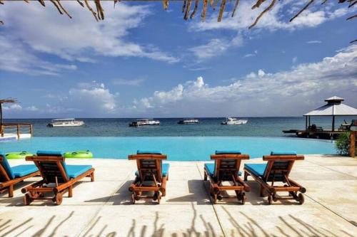 a pool with chairs and the ocean in the background at Paris' -Oasis in Discovery Bay