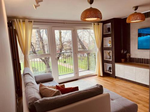a living room with a couch and a large window at Two Bedroom Apartment near Central Line in London