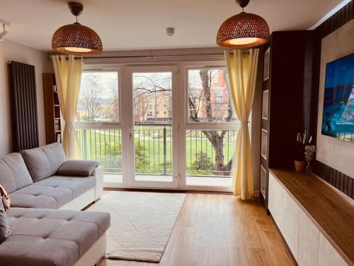 a living room with a couch and a large window at Two Bedroom Apartment near Central Line in London