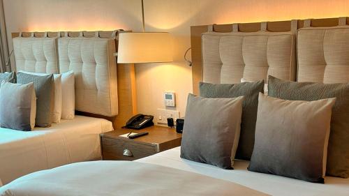 a hotel room with a bed with pillows and a phone at Cartesiano Boutique & Wellness Hotel in Puebla