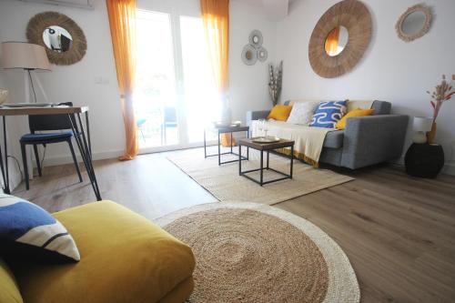 een woonkamer met een bank en een tafel bij Studio grande piscine dans résidence hôtelière, proche plage in Lecci