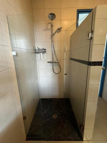 a bathroom with a shower with a glass door at El nido del tucán in Torio