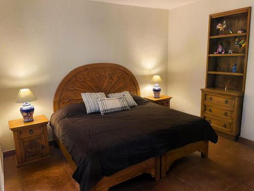 een slaapkamer met een groot bed met 2 nachtkastjes bij LAS ALAMEDAS Departamentos céntricos con estacionamiento privado in Guanajuato