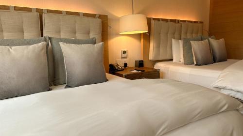 a hotel room with two beds with pillows at Cartesiano Boutique & Wellness Hotel in Puebla