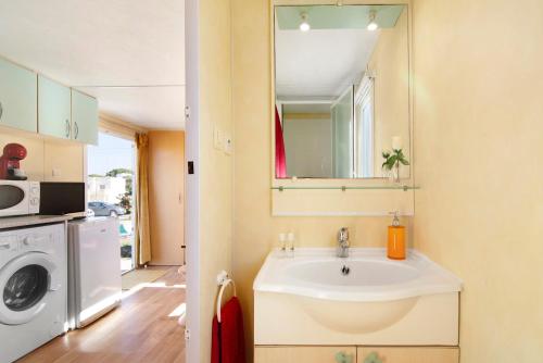 a bathroom with a sink and a washing machine at Mobile Home 1 - Olhão in Quelfes