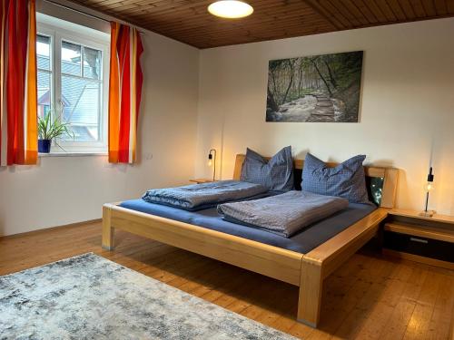 een slaapkamer met een bed met blauwe lakens en kussens bij Traumhaft große Ferienwohnung nähe Attersee in Sankt Georgen im Attergau