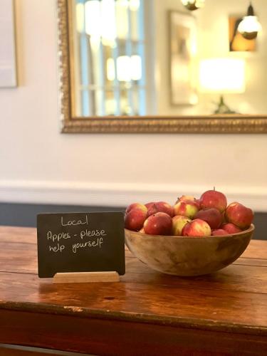 a bowl of apples on a table with a sign at The Nutmeg Vermont in Wilmington