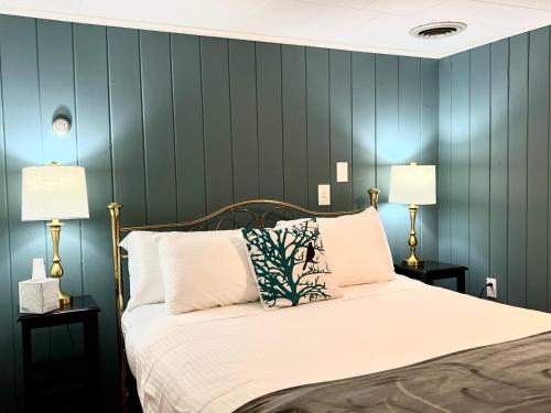 a bedroom with a large bed with two lamps at The Nutmeg Vermont in Wilmington