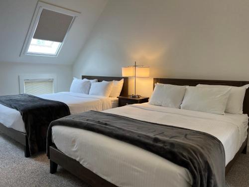 a bedroom with two beds and a skylight at The Nutmeg Vermont in Wilmington