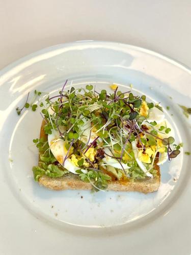 a white plate with a piece of bread with salad on it at The Nutmeg Vermont in Wilmington