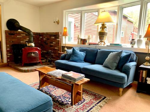 a living room with a blue couch and a wood stove at The Nutmeg Vermont in Wilmington
