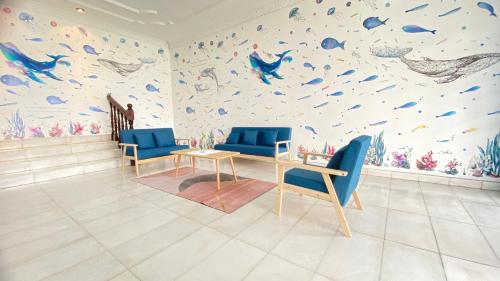 a room with blue chairs and a wall with fishes at 吉隆坡疯鱼民宿Crazy Fish Homestay KL in Petaling Jaya