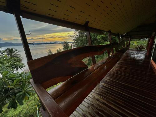 a wooden bench sitting on top of a beach at Good View House - Koh Yao Noi in Ko Yao Noi