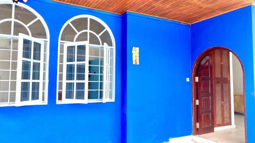 a blue wall with two windows and a red door at 吉隆坡疯鱼民宿Crazy Fish Homestay KL in Petaling Jaya