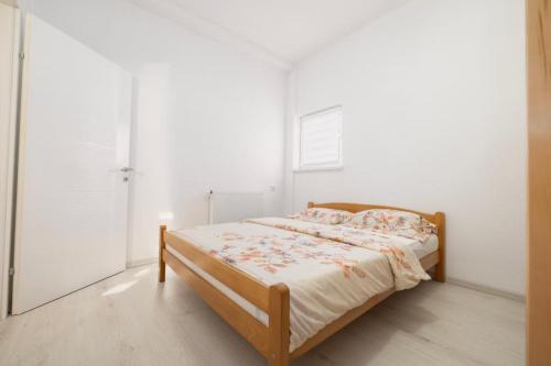 a bed in a bedroom with a white wall at Apartman BARIŠIĆ 1 in Kupres